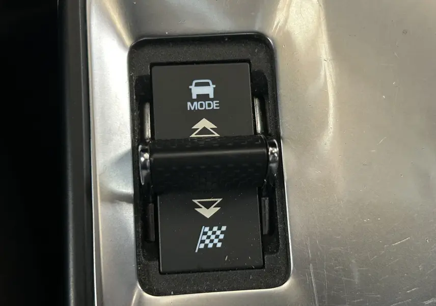 Gros plan sur le bouton de sélection de mode de conduite dans l’habitacle du Jaguar E-PACE beige.