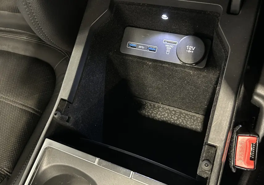 Gros plan sur la console centrale intérieure du Jaguar E-PACE, montrant prises USB, port micro SIM et prise 12V.
