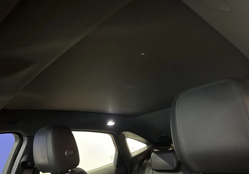 Vue intérieure arrière du Jaguar E-PACE 2018, montrant les sièges cuir noirs et le toit panoramique fermé.