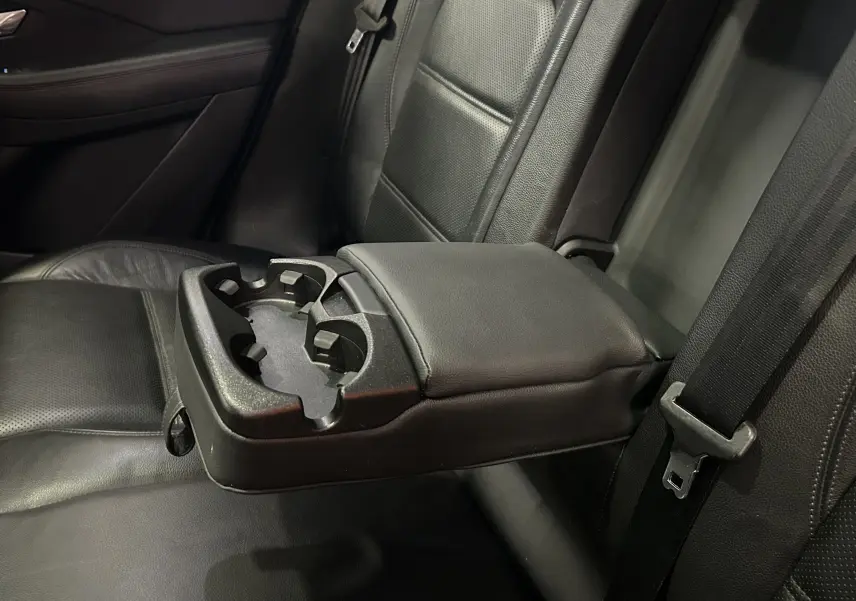 Détail de l'accoudoir central arrière en cuir noir avec porte-gobelets dans le Jaguar E-PACE 2018.