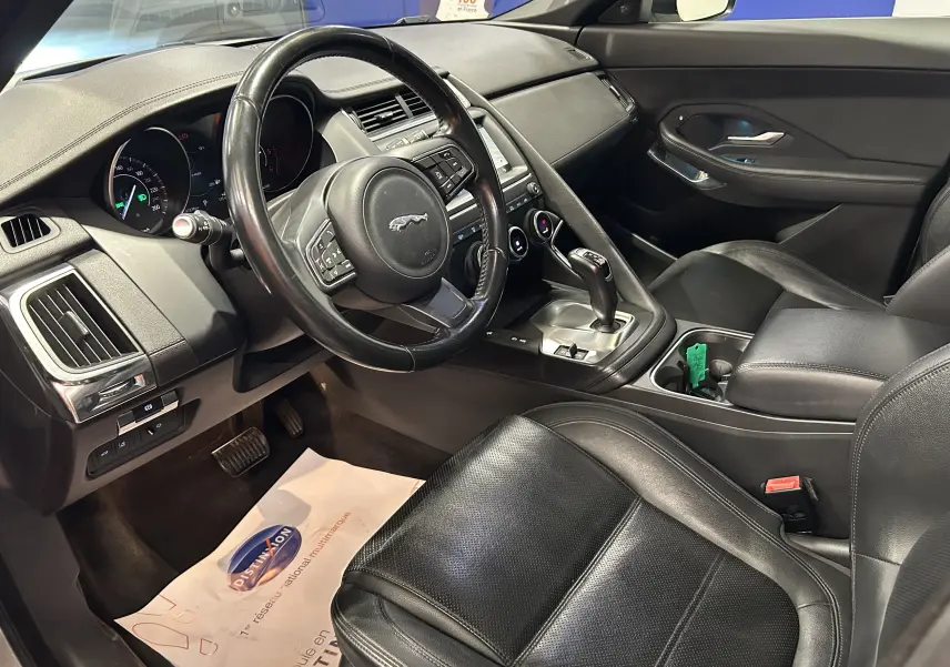 Vue intérieure côté conducteur du Jaguar E-PACE 2018 avec sièges cuir noirs et console centrale équipée d'une boîte automatique.