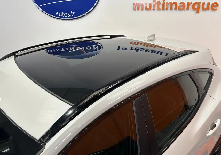 Vue en plongée du toit panoramique noir sur Jaguar E-PACE beige, avec vitrage latéral teinté et antenne requin.