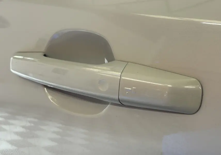 Poignée de porte beige vue en gros plan sur une Jaguar E-Pace 2018, finition R-Sport avec peinture métallisée.