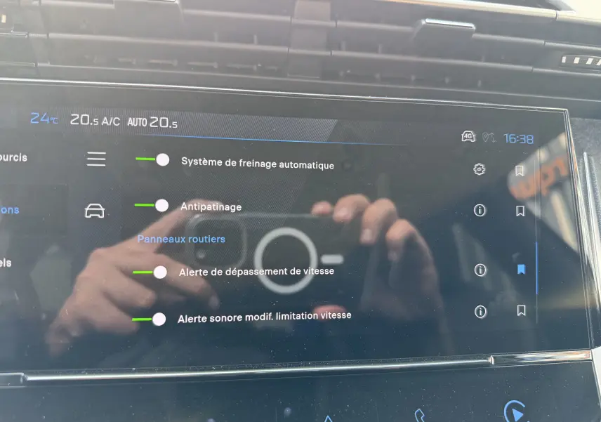 Écran tactile intérieur de la Peugeot 308 gris Artense montrant les réglages d’aides à la conduite à 16h38