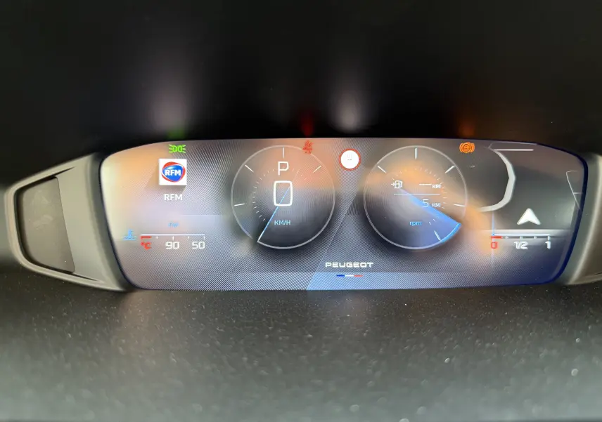 Tableau de bord numérique de la Peugeot 308 2025 affichant la vitesse, régime, température moteur et radio RFM.