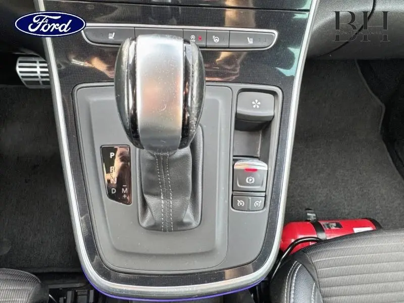 Vue rapprochée du levier de vitesses automatique noir et chrome du Renault Grand Scenic 2017, avec boutons de contrôle et tapis noir.