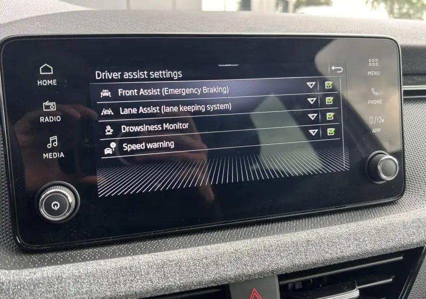 Écran tactile central affichant les réglages d'assistance à la conduite dans l'habitacle d'une Skoda Scala.