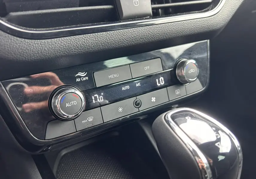 Gros plan sur la console centrale noire du Skoda Scala 2025, montrant la climatisation automatique bi-zone et le levier de vitesse.