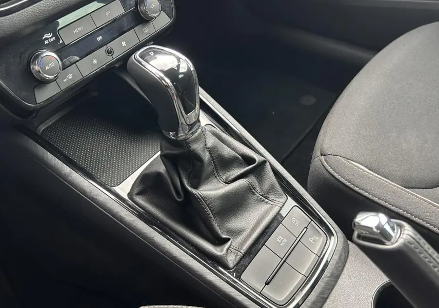 Gros plan sur la console centrale intérieure de la Skoda Scala TSI 116 DSG7 avec levier de vitesse automatique et commandes.