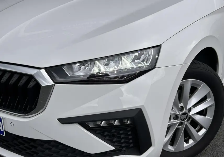 Gros plan sur l'avant droit blanc Candy d'une Skoda Scala 2025, mettant en valeur le phare Full LED et la jante alliage 16 pouces.