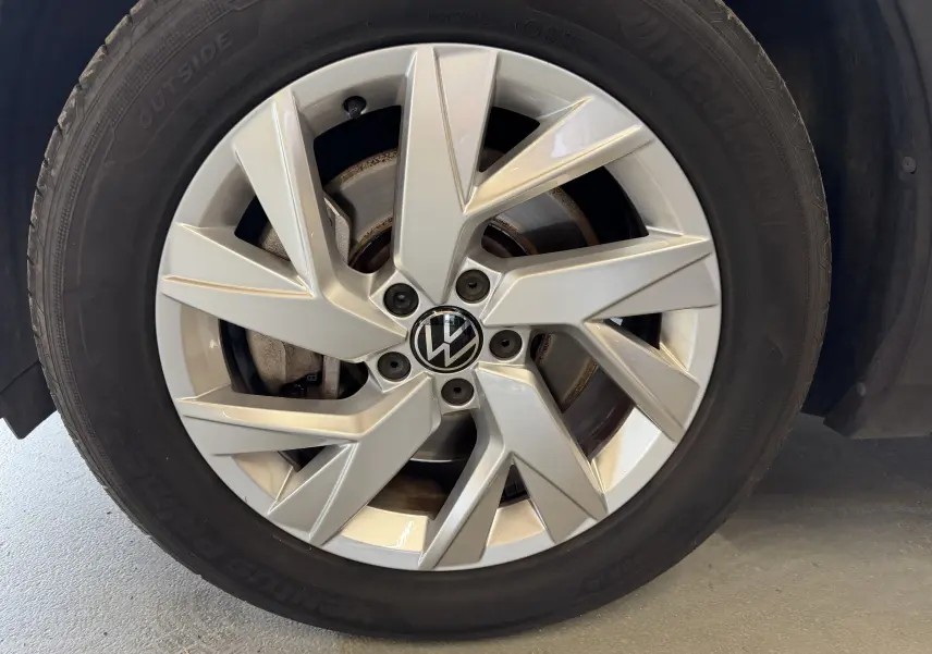Gros plan sur la jante argentée en alliage du Volkswagen Tiguan 1.4 E-HYBRID 2022 avec logo VW au centre.