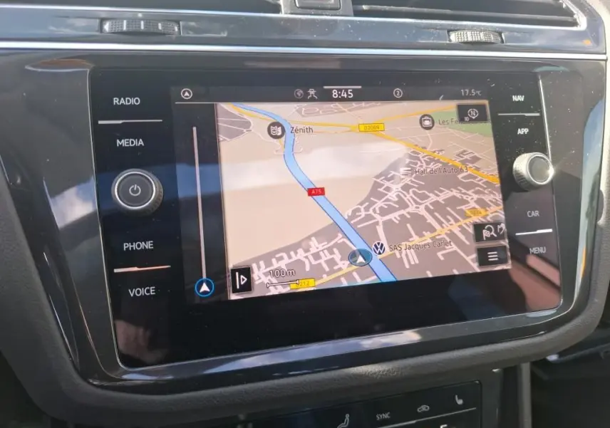 Vue rapprochée de l’écran tactile du système de navigation du Volkswagen Tiguan gris clair 2022, affichant une carte routière.