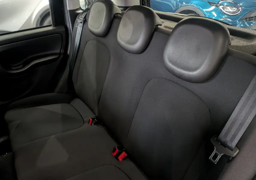 Vue rapprochée des sièges arrière en tissu noir de la Fiat Panda 1.0 70 CH Hybrid City 2025, avec ceintures visibles.