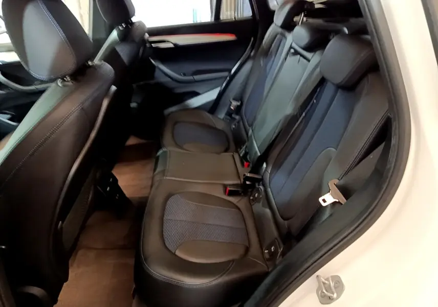 Vue intérieure côté droit des sièges arrière en cuir noir du BMW X1 sDrive18i M Sport blanc de 2022.
