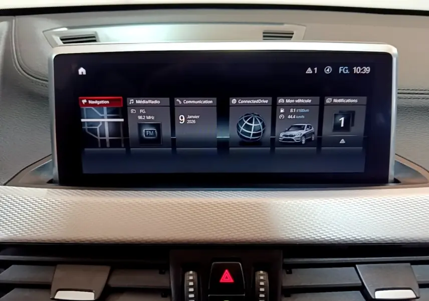 Écran tactile central 8,8 pouces du BMW X1 blanc, affichant navigation et informations du véhicule.