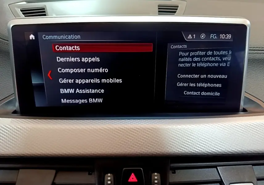 Écran tactile central 8,8 pouces affichant le menu communication dans l’habitacle d’une BMW X1 blanche.