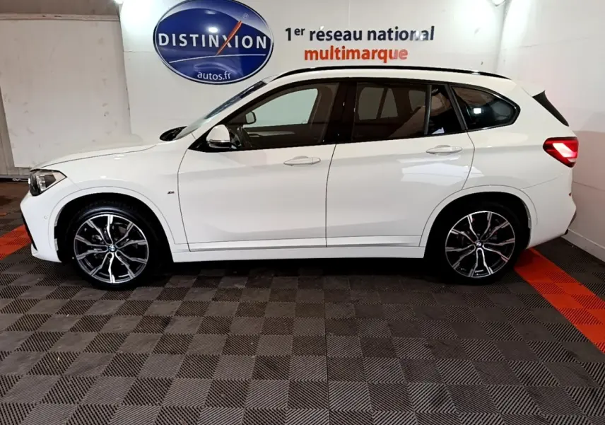 BMW X1 sDrive18i M Sport blanc vue de profil côté gauche avec jantes alliage et vitres teintées.