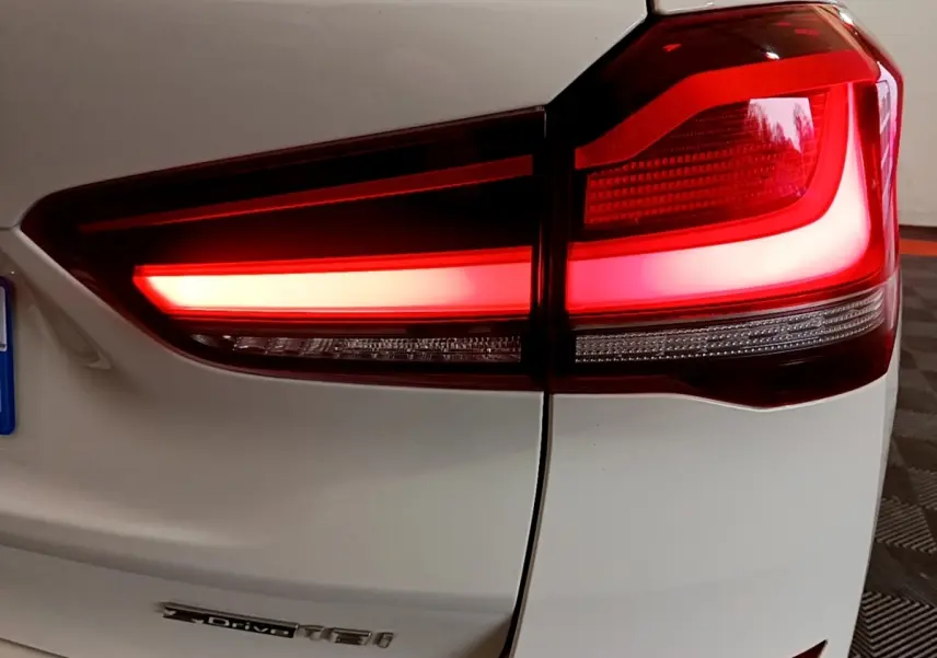 Gros plan sur le feu arrière droit rouge d’un BMW X1 blanc sDrive18i M Sport 2022.