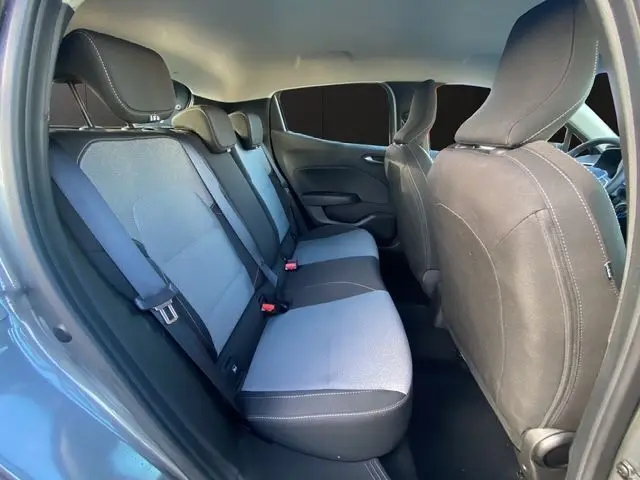 Vue latérale intérieure côté droit de la Renault Clio V gris schiste, montrant la banquette arrière en textile gris à motif 3D.