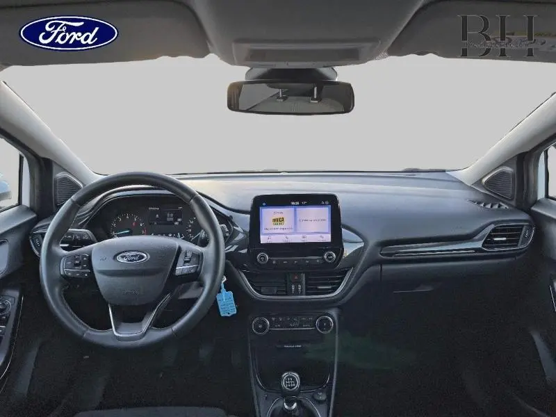 Vue frontale de l'habitacle du Ford Puma blanc avec volant multifonction et écran tactile central.