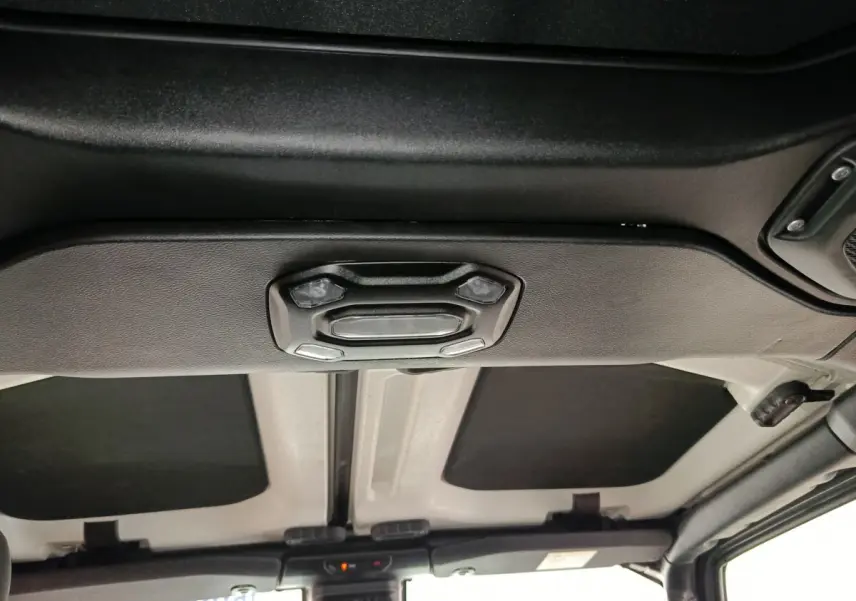 Vue intérieure du toit cabriolet gris foncé du Jeep Wrangler 2022 avec commandes d'éclairage intégrées au plafond.