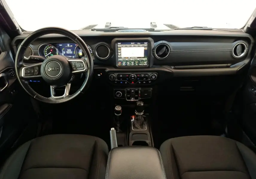 Vue intérieure frontale du tableau de bord noir du Jeep Wrangler 2022 avec écran tactile central et volant cuir multifonctions.