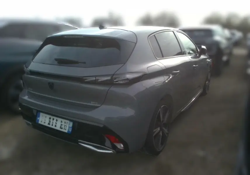 Peugeot 308 gris clair vue 3/4 arrière droit, mettant en valeur ses feux LED et son design dynamique.
