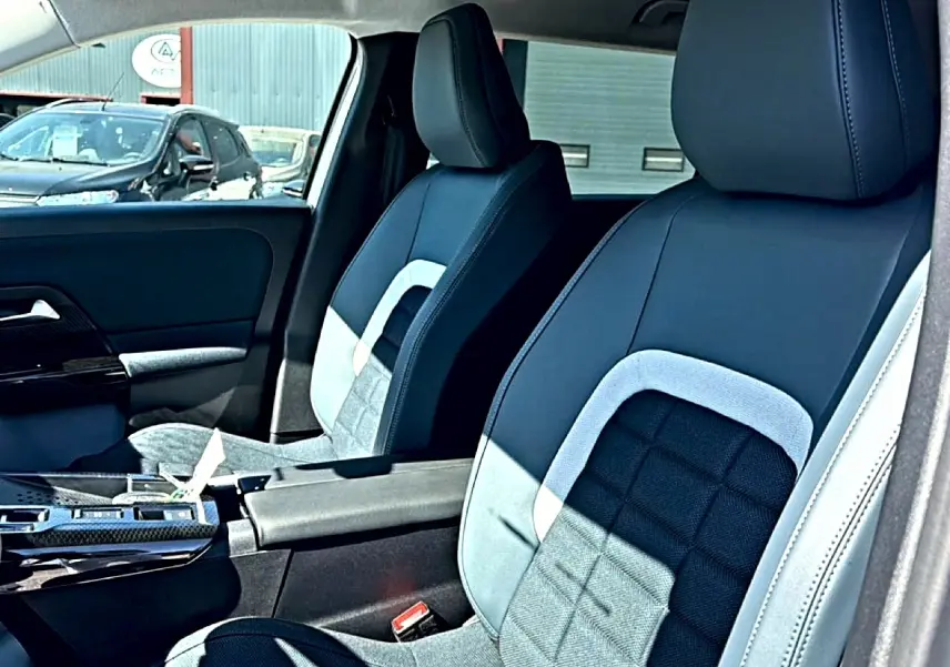 Vue intérieure côté conducteur du Citroën C5 Aircross 2026, sièges bi-matière noir et gris avec accoudoir central.