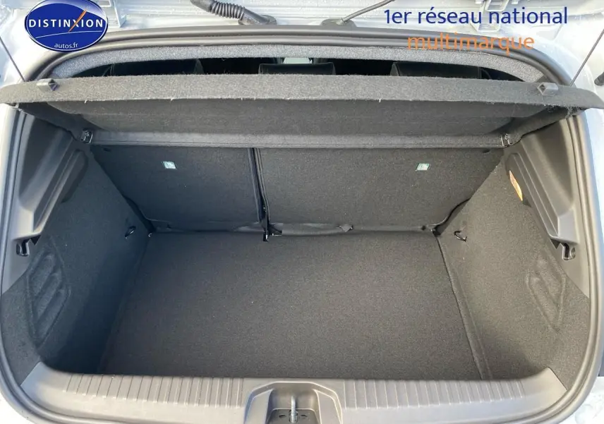 Coffre ouvert vu de dessus d'une Renault Clio V gris rafale, montrant l'espace de rangement et la tablette cache-bagages.