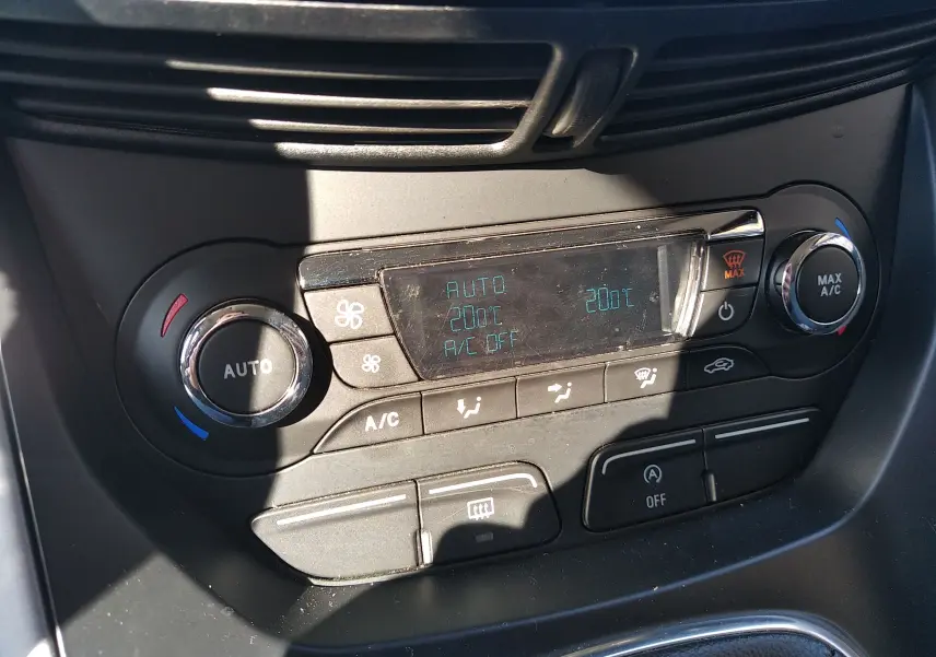 Gros plan sur la console de climatisation automatique du Ford C-MAX blanc, affichant 20°C et commandes tactiles.