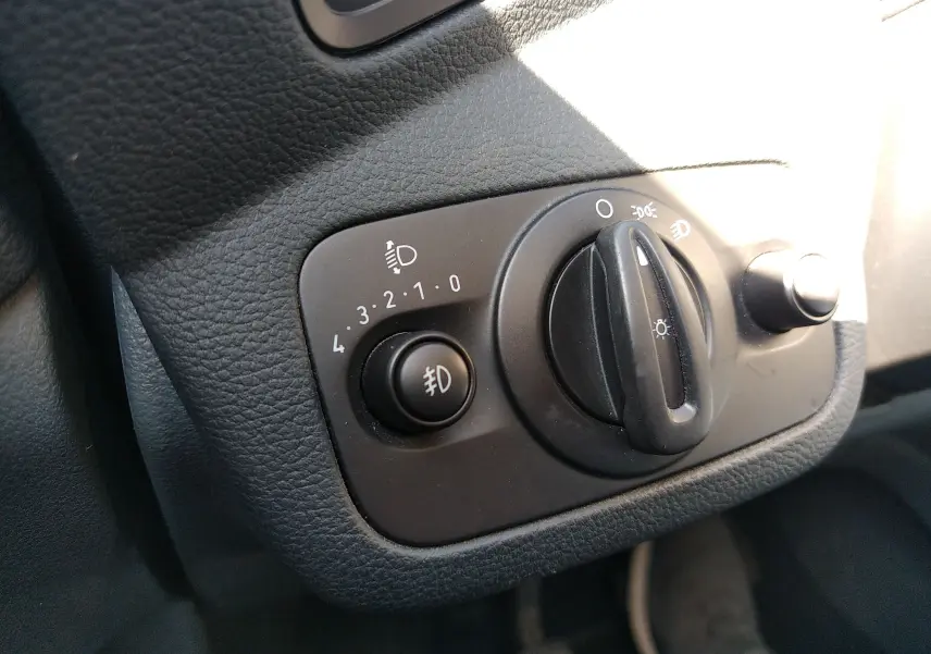 Gros plan sur le bouton de commande des phares et des feux antibrouillard dans l’habitacle d’une Ford C-MAX blanc de 2013.