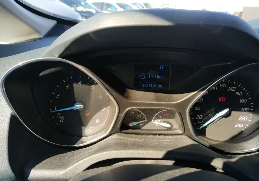 Vue rapprochée du tableau de bord du Ford C-MAX blanc 2013 montrant compte-tours, vitesse et écran digital.