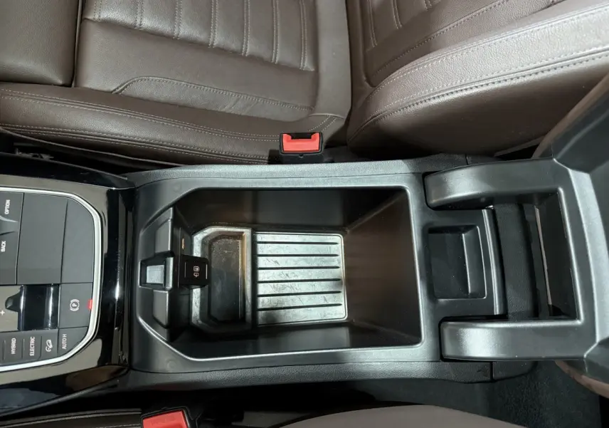 Vue plongeante sur la console centrale noire et les sièges en cuir marron du BMW X3 xDrive30e 2023.