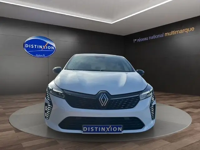 Renault Clio V blanc vue de face en intérieur, avec calandre noire et éclairage LED distinctif Pure Vision.