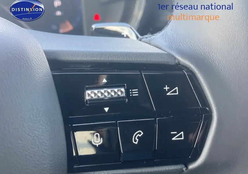 Gros plan sur les commandes vocales et téléphone au volant de l'Alfa Romeo Junior 1.2 hybride gris/noir, intérieur moderne.