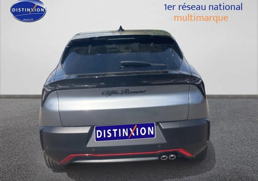 Vue arrière d'une Alfa Romeo Junior 1.2 hybride gris foncé avec double sortie d'échappement et lunette arrière teintée.