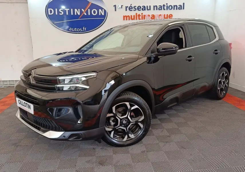 Citroën C5 Aircross noir vue 3/4 avant droit en intérieur avec jantes distinctives et calandre moderne.