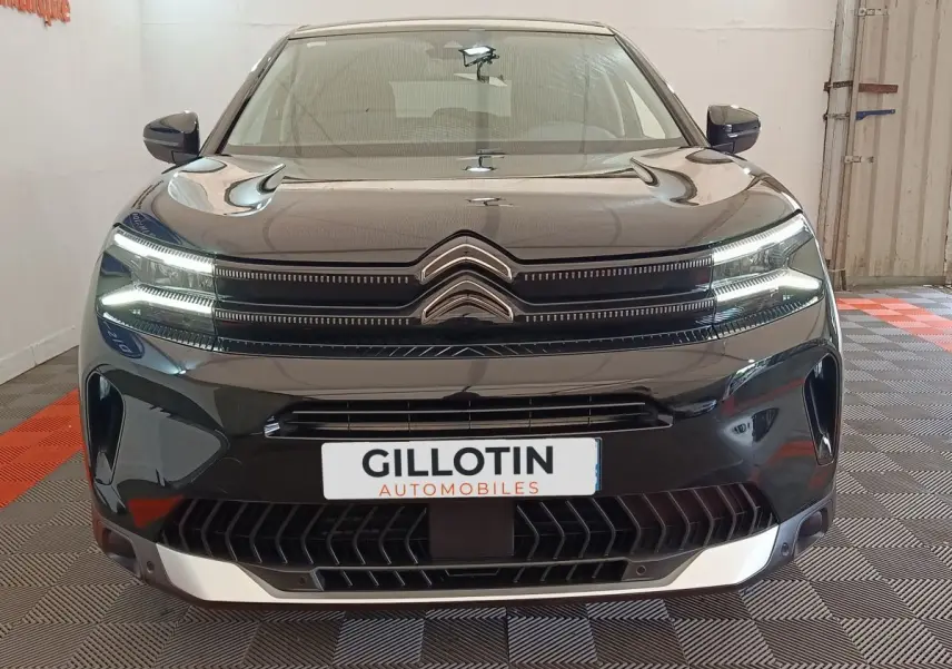 Vue avant d'un Citroën C5 Aircross noir 2024 avec calandre distinctive et phares LED allumés.