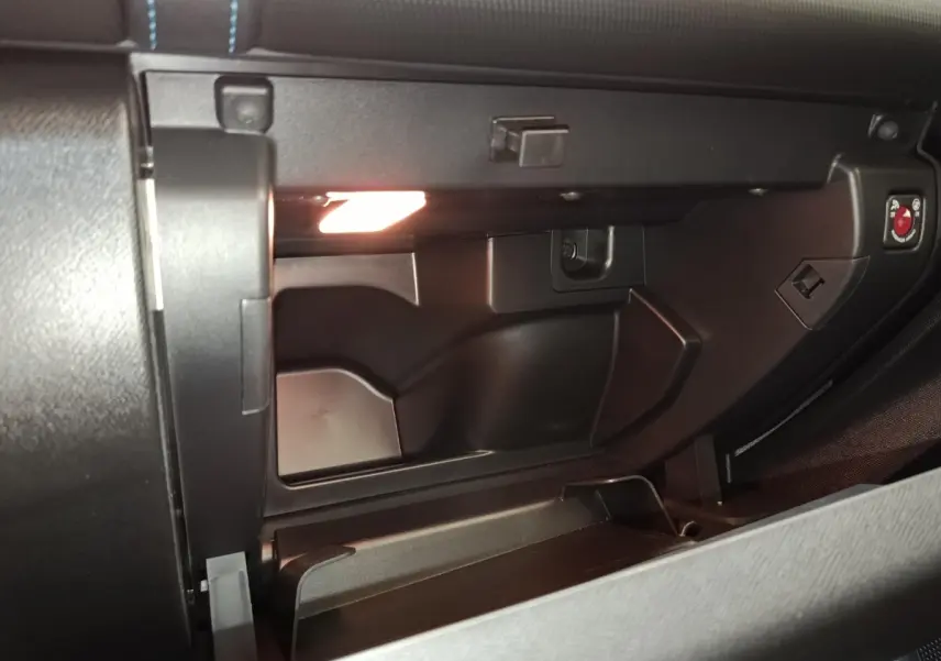 Intérieur du vide-poches ouvert côté passager du Citroën C5 Aircross noir, éclairage intérieur visible.