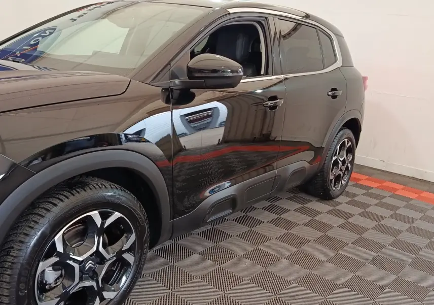 Vue côté gauche 3/4 arrière du Citroën C5 Aircross noir avec jantes alliage et protections de bas de caisse.