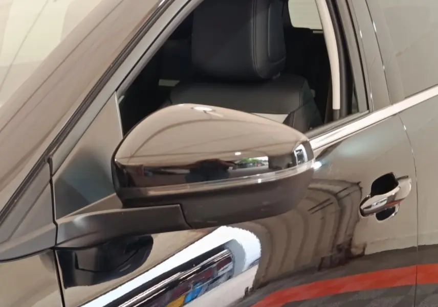 Gros plan sur le rétroviseur côté gauche d’un Citroën C5 Aircross noir 2024 avec poignée de porte visible.