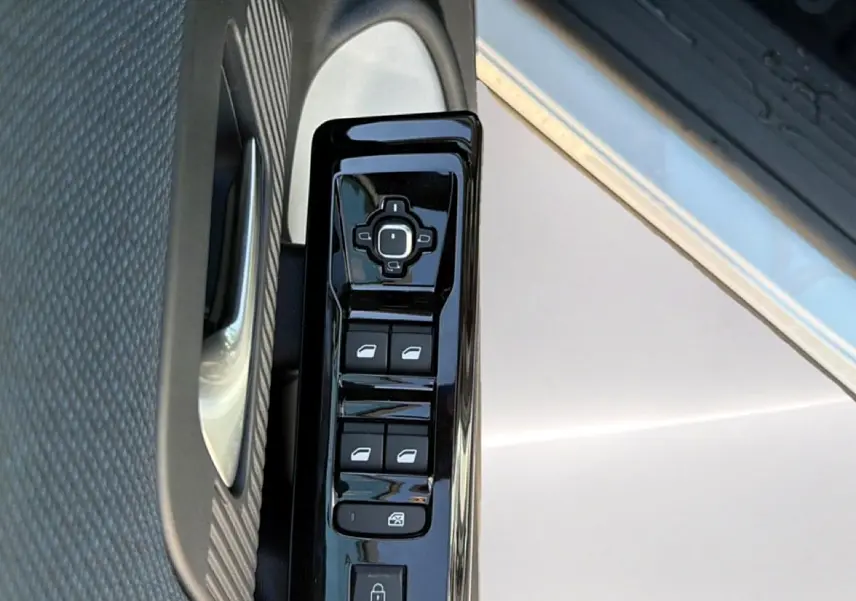 Gros plan sur les commandes de lève-vitres et rétroviseurs côté conducteur d'une Citroën C5 Aircross blanc et noir.