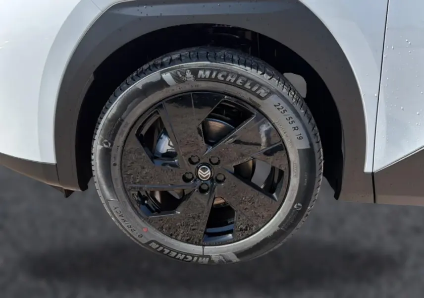 Gros plan sur la roue avant droite du Citroën C5 Aircross blanc avec jante alliage noire 19 pouces et pneu Michelin.