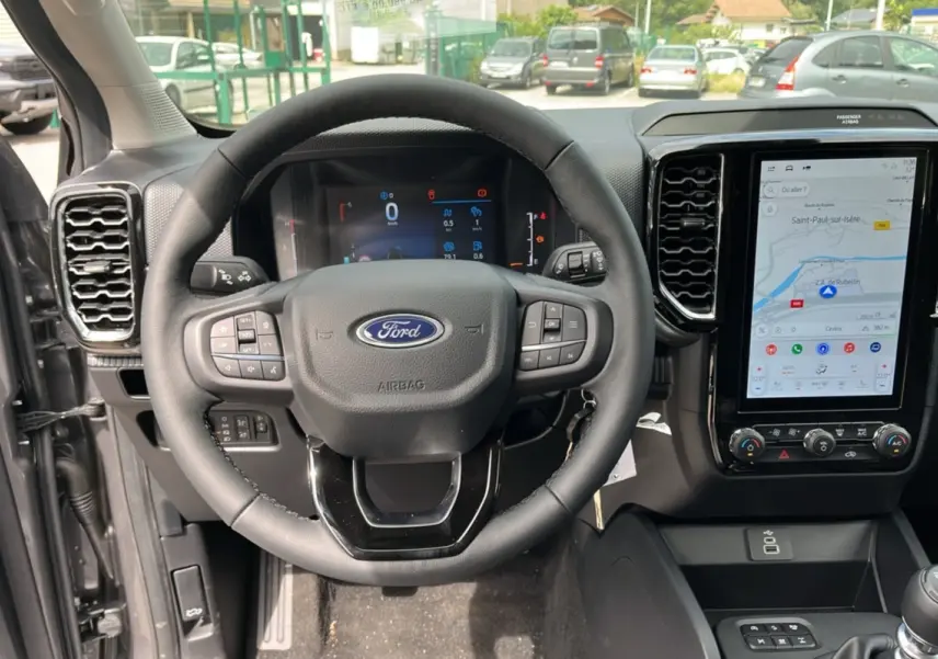 Vue intérieure centrée sur le volant et l'écran tactile du Ford Ranger gris carbone 2025, version XLT Supercab.