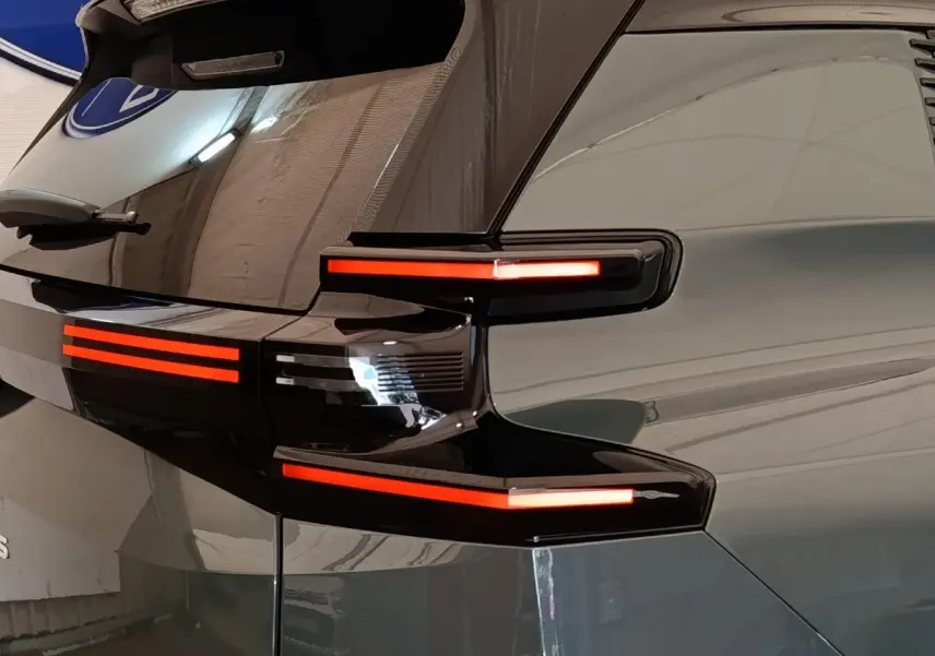 Gros plan sur l’arrière droit vert du Citroën C5 Hybride 2026, avec feux LED horizontaux distinctifs allumés.