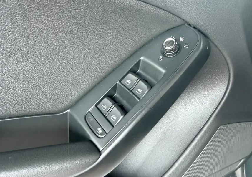 Gros plan sur les commandes des vitres électriques et rétroviseurs côté conducteur d'une Audi A5 Sportback 2009.