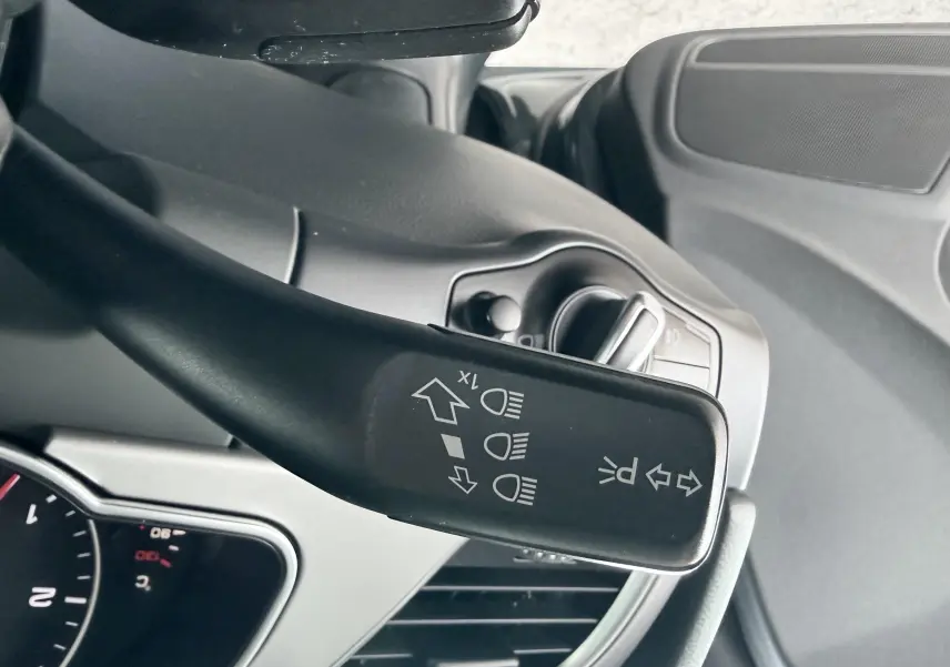 Gros plan sur le commodo gauche du tableau de bord de l'Audi A5 Sportback gris dauphin, montrant les commandes d'éclairage.