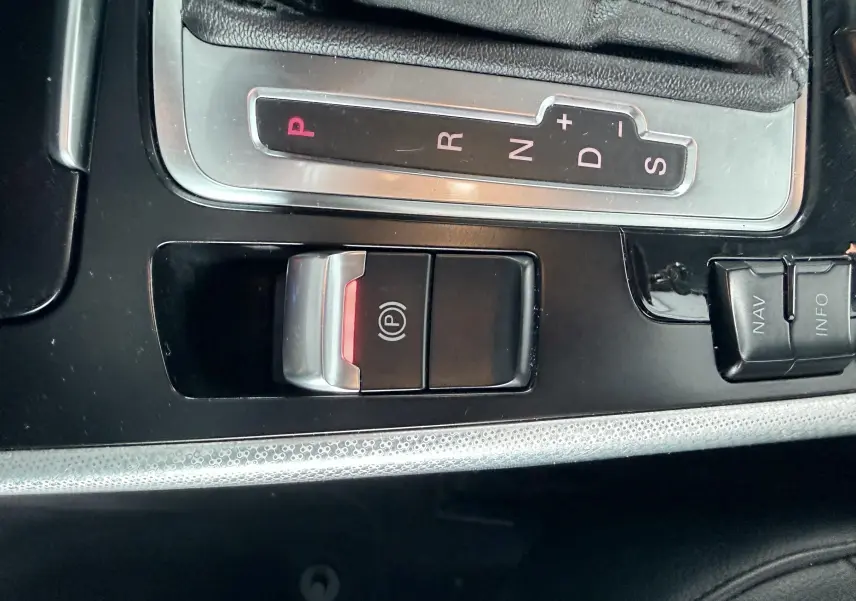Gros plan sur la console centrale noire de l’Audi A5 Sportback avec levier de vitesse automatique et frein à main électronique.