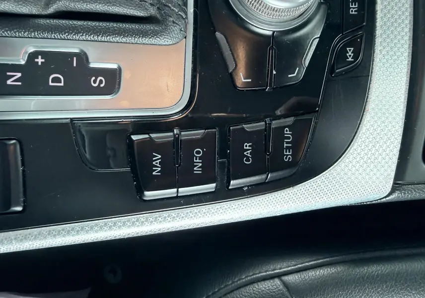 Gros plan sur la console centrale noire et argentée de l'Audi A5 Sportback avec les boutons de navigation et commande de boîte auto.