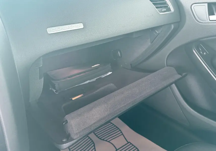 Intérieur de l'Audi A5 Sportback 2009, vue sur la boîte à gants ouverte côté passager avec logo Quattro visible.